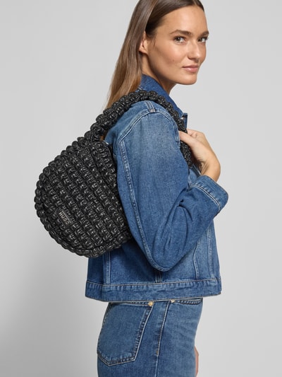 Frauenmodel trägt Henkeltasche mit Label-Applikation Modell 'Mhati' von HUGO in Optik: Unifarben, Lederoptik, quadratische Form, Nahaufnahme Oberkörper.