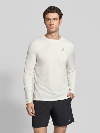 Männermodel trägt Regular Fit Langarmshirt mit Logo-Print von ASICS in Weiß, schlichte Optik, Rundhalsausschnitt, Ganzkörperansicht von vorne. Rückenlänge bei Größe M: 72 cm.