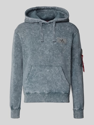 Produktfoto, Relaxed Fit Hoodie aus Baumwoll-Mix mit Logo-Patch von Alpha Industries in verwaschenem Blau, Kängurutasche, gerippte Abschlüsse, sichtbare Armtasche mit Zipper, strukturierte Oberfläche, Kapuze mit Tunnelzug, langärmeliges Design