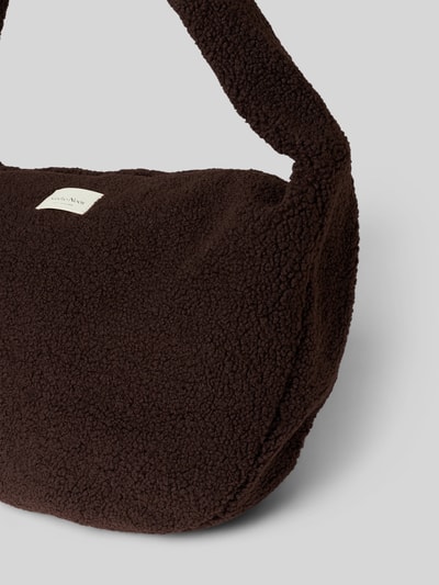 Produktfoto, Crossbody Bag aus Teddyfell von Studio Noos in Dunkelbraun mit Logo-Patch, Reißverschluss und Schulterriemen, weiche texturierte Oberfläche, Damen Crossbody Bag, Hauptfach und Patch sichtbar, Kontext: Breite 58 cm, Länge 35 cm, Tiefe 11 cm, Riemenlänge 80 cm