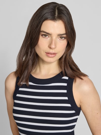Frauenmodel trägt Tanktop mit Rippenstruktur Modell 'OLINA' von Drykorn, Reine Baumwolle, Rundhalsausschnitt, eng anliegender Schnitt, Nahaufnahme Oberkörper.