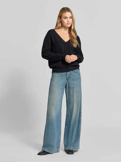 Kobiece modelka nosi sweter z dzianiny z mieszanką lnu, efekt prążkowania, dekolt w serek, luźny krój, Model 'DAMSVILLE' od American Vintage, długość tyłu w rozmiarze XS/S: 61 cm, długość rękawa: 54 cm, widok całej sylwetki z przodu.