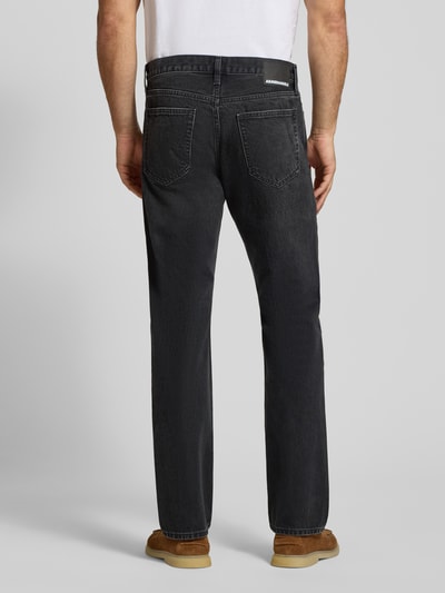 Männermodel trägt Straight Fit Jeans aus reiner Baumwolle Modell 'MAADOX' von ARMEDANGELS in Schwarz, grobe Denim-Textur, Ganzkörperansicht Rückansicht. Herren Straight Fit Jeans von ARMEDANGELS.