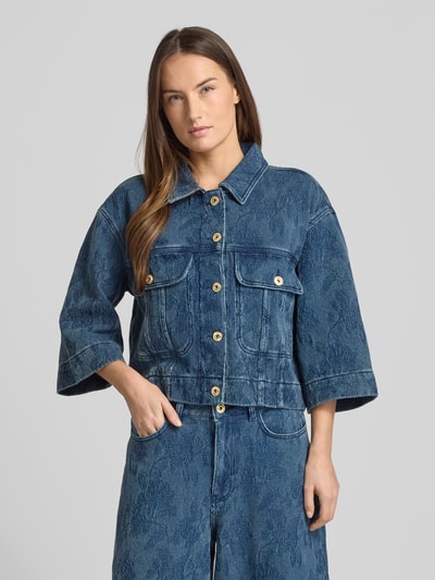 Frauenmodel trägt Relaxed Fit Jacke in Denim-Optik Modell 'Penn' von MOS MOSH in Blau mit floraler Allover-Stickerei, Ganzkörperansicht von vorne. 3/4-Arm, cropped, reine Baumwolle, Umlegekragen, Brusttaschen, Knopfleiste.