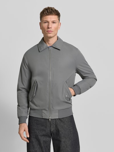 Männermodel trägt Jacke mit Reißverschluss von MCNEAL in Grau mit Kentkragen, Pattentaschen, gerippten Abschlüssen, Ganzkörperansicht von vorne. Kontext: Herren Jacke, Regular-Fit, Rückenlänge bei Größe M: 68 cm, Schulterbreite: 48 cm, Brustweite: 57 cm, Ärmellänge: 65 cm.
