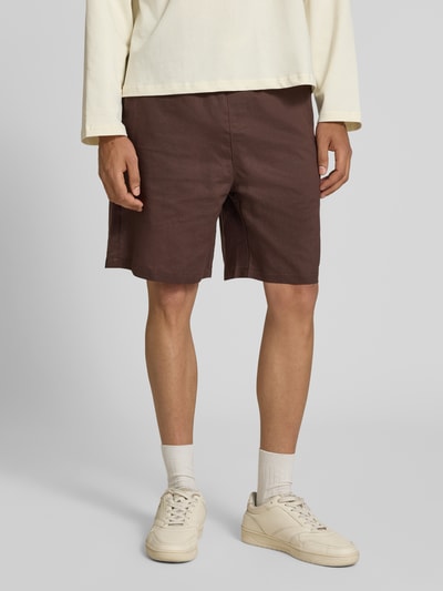 Männermodel trägt Leinenshorts mit elastischem Bund und Tunnelzug von ANOTHER COTTON LAB in Braun, Regular-Fit, Ganzkörperansicht von vorne.