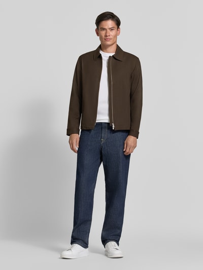 Männermodel trägt Regular Fit Blouson mit Viskose-Anteil Modell 'REGULAR' von Selected, Herren Bomberjacke, braun, weiße Schuhe, blaue Jeans, Ganzkörperansicht von vorne.