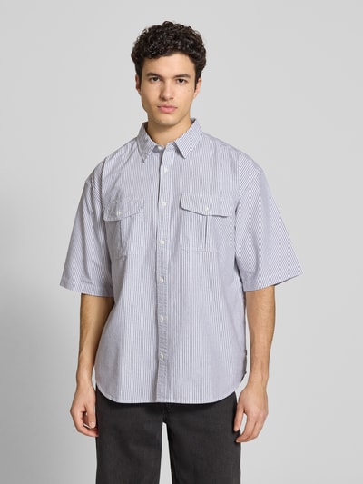 Männermodel trägt Loose Fit Freizeithemd aus reiner Baumwolle Modell 'PACIFICA' von Levi's® mit Optik:Allover-Muster, gestreift, Hemdkragen, einreihiger Knopfleiste, Kurzarm, abgerundetem Rumpfabschluss und Brusttaschen, Ganzkörperansicht von vorne.