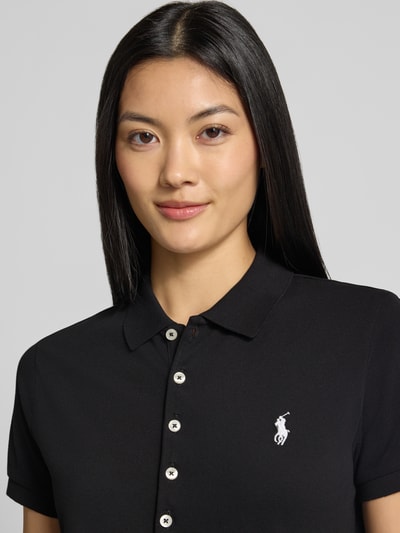 Frauenmodel trägt Slim Fit Poloshirt aus Baumwoll-Mix von Polo Ralph Lauren in Schwarz mit weißen Knöpfen, Nahaufnahme Oberkörper. Damen Poloshirt von Polo Ralph Lauren