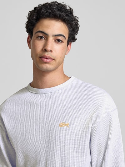 Männermodel trägt Longsleeve mit Logo-Stitching van BLKVIS uit puur katoen met structuurpatroon, loose fit, ronde hals, ruglengte bij maat S 75 cm, Nahaufnahme Oberkörper.