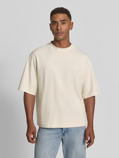 Männermodel trägt Boxy Fit T-Shirt aus reiner Baumwolle Modell 'CORY' von Selected Homme, Herren T-Shirt, cremefarben, Ganzkörperansicht von vorne.