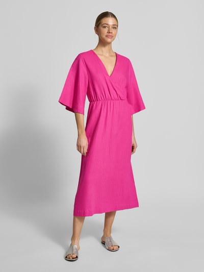 Frauenmodel trägt Midikleid aus Leinen-Mix mit Kimonoärmeln Modell 'Laura' von GUIDO MARIA KRETSCHMER WOMAN in Pink, taillierter Schnitt, V-Ausschnitt, Wickel-Optik, Leinen-Viskose-Mix, Ganzkörperansicht von vorne.