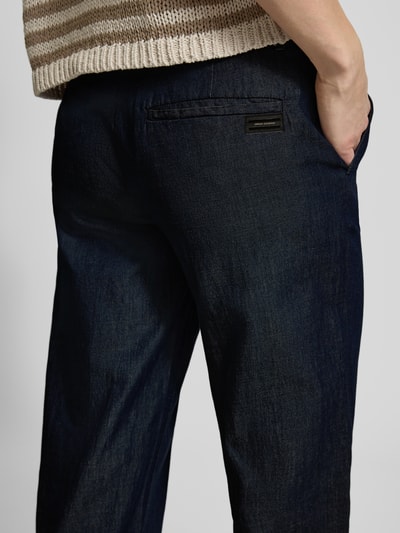 Vrouwenmodel draagt Hose mit Gesäßtasche van ARMANI EXCHANGE in donkerblauw, relaxed fit, katoen, met achterzak, detailopname achterkant.