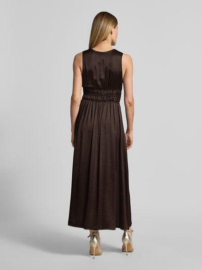 Frauenmodel trägt Maxikleid mit tiefem V-Ausschnitt Modell 'Marja' von mbyM im Material-Mix mit Viskose-Anteil, Taillierter Schnitt, Rückenlänge 130 cm, Brustweite 36 cm, dunkler Farbton, seidige Textur, Ganzkörperansicht Rückansicht.