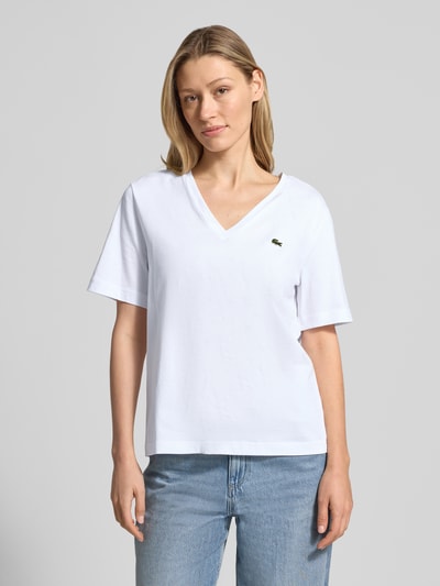 Frauenmodel trägt Relaxed Fit T-Shirt aus reiner Baumwolle von Lacoste, Optik: Unifarben, Logo-Stitching, V-Ausschnitt; Ganzkörperansicht von vorne.