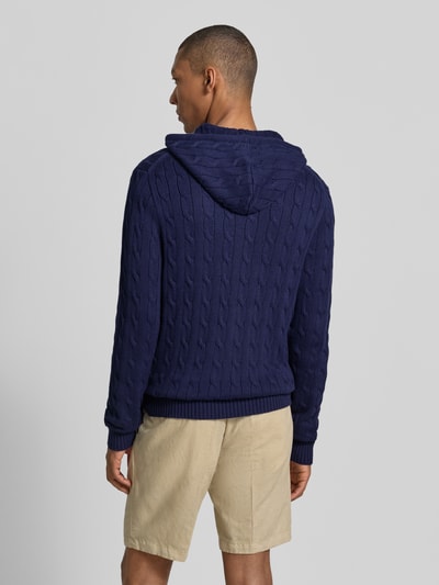 Mężczyzna model nosi Regular Fit Strickjacke aus reiner Baumwolle von Polo Ralph Lauren, kolor granatowy, widok całej sylwetki z tyłu.