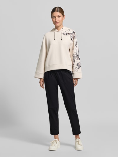 Frauenmodel trägt Hose mit elastischem Bund und Eingrifftaschen von Marc Cain in Schwarz, Material-Mix mit Stretch, Regular Fit, Ganzkörperansicht von vorne.