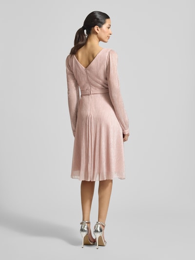Kobiece model prezentuje Regular Fit Kleid in Wickel-Optik od TROYDEN COLLECTION, błyszcząca siateczka, krój regular fit, kopertowy styl, dekolt w serek, z długim rękawem, taliowany krój, wykończenia rękawów obszyte, wszyty zamek błyskawiczny, długość tyłu w rozmiarze 36: 90 cm, szerokość klatki piersiowej w rozmiarze 36: 37 cm, długość rękawów w rozmiarze 36: 67 cm, jasnoróżowe, całkowity widok z tyłu