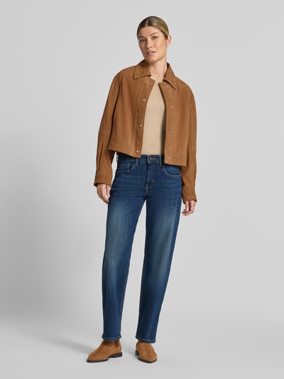 Frauenmodel trägt Straight Fit Jeans aus Baumwoll-Mix von MAC in mittlerem Blau, kombiniert mit brauner Jacke und beigen Schuhen, Ganzkörperansicht von vorne, Damen Straight Fit Jeans von MAC.