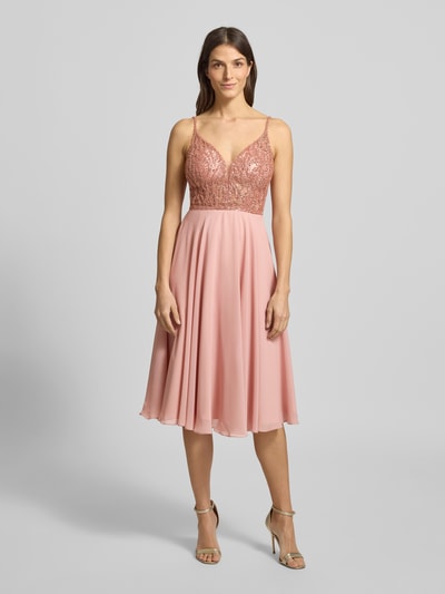 Frauenmodel trägt Regular Fit Minikleid mit Ziersteinbesatz von Hey Kyla in Rosa, tiefer V-Ausschnitt, semitransparent, Spaghettiträger, Ganzkörperansicht von vorne.