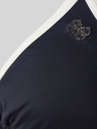 Frauenmodel trägt Bikini-Oberteil mit Logo-Applikation Modell 'Niki' von Guess, Elastischer-Material-Mix, Nahaufnahme Oberkörper.