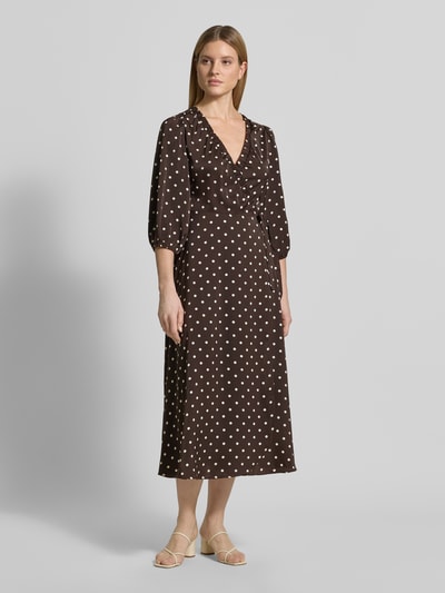 Frauenmodel trägt Regular Fit Maxikleid mit V-Ausschnitt von Neo Noir aus braunem Satin mit weißen Punkten, 3/4-Arm, Ganzkörperansicht von vorne.