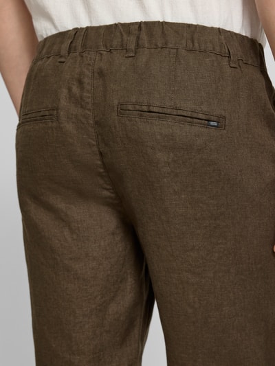 Männermodel trägt Leinen Shorts mit Eingrifftaschen Modell 'PANDRUP' von Casual Friday, braun, reine Leinenstruktur, Detailaufnahme Rückansicht.