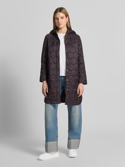 Frauenmodel trägt Regular Fit Mantel in Stepp-Optik Modell 'Solene' von CARS JEANS, dunkle Farbe, Eingrifftasche, Stehkragen, Ganzkörperansicht von vorne.