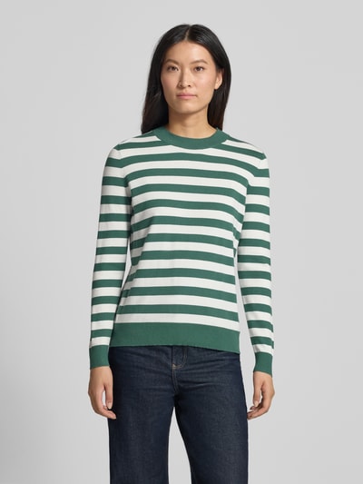 Frauenmodel trägt Strickpullover mit Rundhalsausschnitt von Christian Berg Woman im Viskose-Mix mit tailliertem Schnitt, Ganzkörperansicht von vorne.