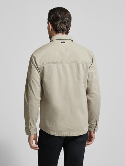 Męski model nosi Regular Fit Hemdjacke mit Brusttaschen od camel active w beżowym kolorze, bawełniany miks z dodatkiem stretchu, krój regular fit, kołnierzyk kent, zapięcie na guziki, przednie kieszenie na piersi, długość tyłu w rozmiarze M: 74 cm, szerokość ramion w rozmiarze M: 47 cm, szerokość w rozmiarze M: 58 cm, długość rękawa w rozmiarze M: 66 cm, widok całkowity od tyłu.