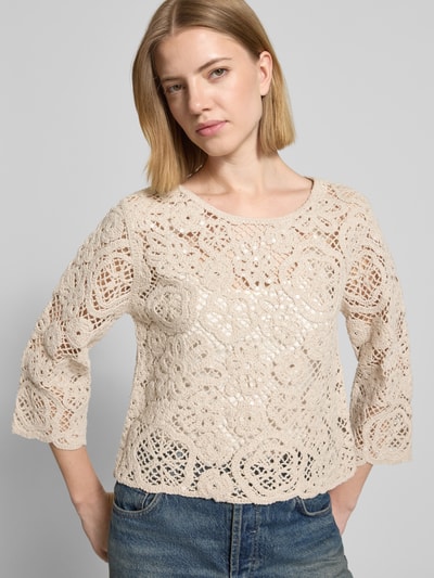 Frauenmodel trägt Relaxed Fit Pullover in Strick-Optik mit Allover-Pailettenbesatz von Betty Barclay im semitransparenten Baumwoll-Mix, beige, kurze Rückenlänge, langärmelig, gehäkelte Textur, Ganzkörperansicht von vorne.