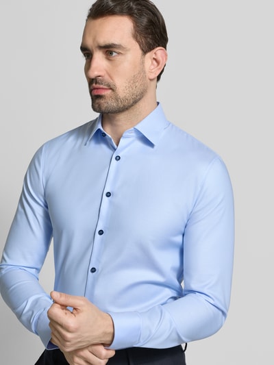 Männermodel trägt Super Slim Fit Business-Hemd mit Kentkragen von OLYMP No. Six in Hellblau, unifarben, Nahaufnahme Oberkörper. Baumwoll-Elasthan-Mix, Rückenlänge 81 cm, Schulterbreite 44 cm, Ärmellänge 68 cm.