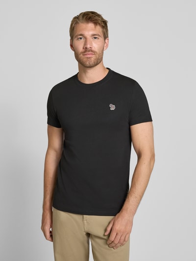 Männermodel trägt Regular Fit T-Shirt aus reiner Baumwolle von Paul Smith in Schwarz, Label-Stitching, Nahaufnahme Oberkörper.