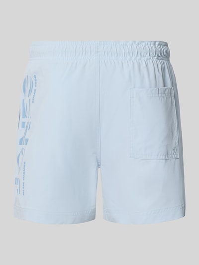 Produktfoto, jasnoniebieskie spodenki kąpielowe z nadrukiem z logo z tyłu, model 'MAUI WAVE' od Jack & Jones, krój regular fit, elastyczny pas