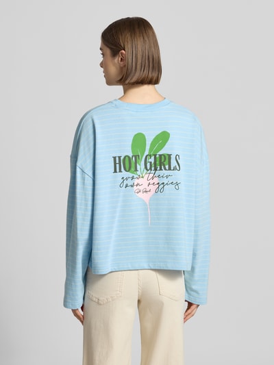 Frauenmodel trägt Longsleeve mit Rundhalsausschnitt von OH APRIL in Hellblau mit weißen Streifen, lockerer Schnitt, Rückenlänge 52 cm, Ganzkörperansicht Rückansicht.