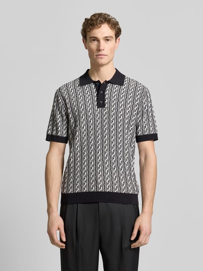 Männermodel trägt Regular Fit Poloshirt mit Polokragen Modell 'Tamian' van Drykorn, katoen, zwart-wit patroon, voorkant, bovenlichaam close-up.
