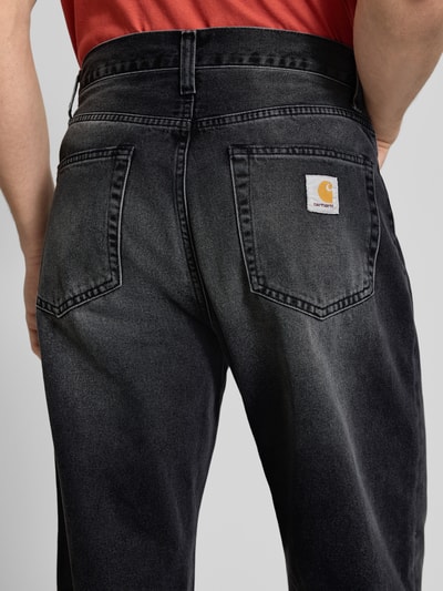Männermodel trägt Carhartt Work In Progress Jeans im 5-Pocket-Design Modell 'Landon', schwarze Baumwolle, Straight Fit, Nahaufnahme Rückansicht.