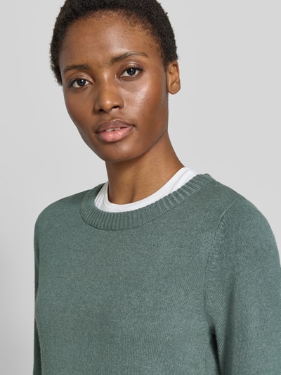 Frauenmodel trägt Strickpullover aus Viskose-Mix von VILA in Grün mit geripptem Rundhalsausschnitt, Nahaufnahme Oberkörper