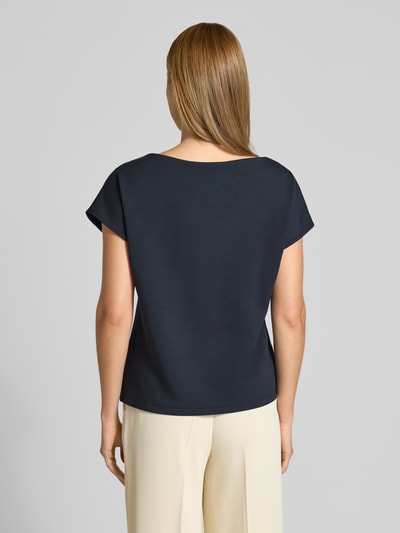 Frauenmodel trägt T-Shirt mit Zierknöpfen und Rundhalsausschnitt von Comma, Viskose-Mix mit Stretch-Anteil, Relaxed-Fit, Rückenlänge 58 cm, Ärmellänge 13 cm, dunkelblau, glatte Textur, Ganzkörperansicht Rückansicht.