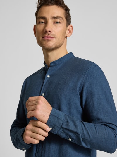 Männermodel trägt Regular Fit Freizeithemd aus Leinen-Baumwoll-Mix von MCNEAL in Blau, Stehkragen, Knopfleiste, Nahaufnahme Oberkörper. Rückenlänge bei Größe M: 76 cm, Schulterbreite: 48 cm, Ärmellänge: 67 cm.