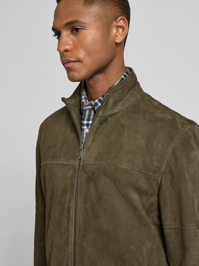 Männermodel trägt Regular Fit Lederjacke aus echtem Ziegenvelours Modell 'JIMMY-S' von Strellson in Oliv mit Stehkragen, Nahaufnahme Oberkörper.