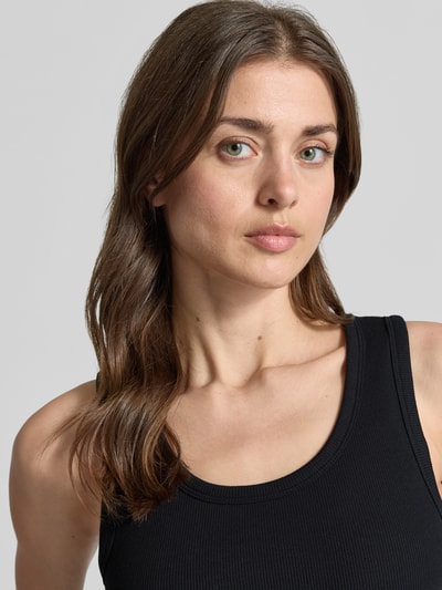 Frauenmodel trägt Slim Fit Top aus Baumwoll-Mix Modell 'CHLOE' von Vero Moda, unifarben, Feinripp, U-Ausschnitt, Nahaufnahme Oberkörper.