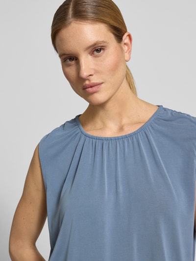 Frauenmodel trägt Loose Fit Blusentop aus Modal-Mix Modell 'FILLI' von Vero Moda in Unifarbe Blau, Stretchmaterial, Nahaufnahme Oberkörper.