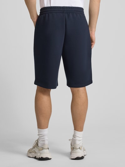 Männermodel trägt Shorts mit elastischem Bund von EA7 Emporio Armani, dunkelblau, Material-Mix, Ganzkörperansicht Rückansicht.