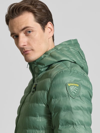 Männermodel trägt Steppjacke mit Zweiwege-Reißverschluss Modell 'Charles' von Blauer Usa, Kapuze, Label-Detail, Nahaufnahme Oberkörper