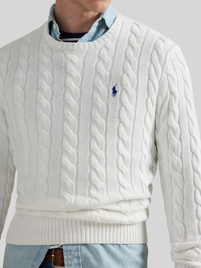 Männermodel trägt Regular Fit Strickpullover aus reiner Baumwolle von Polo Ralph Lauren, weiß, Zopfmuster, Nahaufnahme Oberkörper.