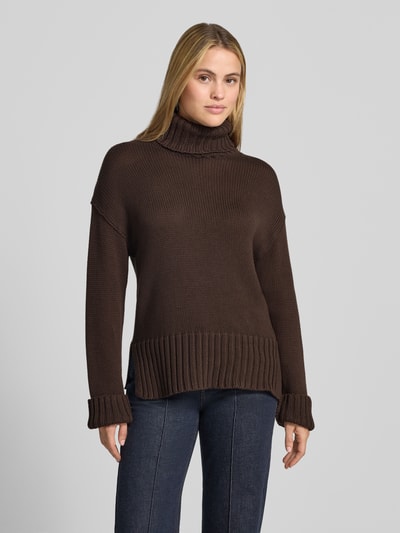 Frauenmodel trägt Relaxed Fit Strickpullover aus reiner Baumwolle mit Rollkragen von MOS MOSH, braun, grobe Strickstruktur, Ganzkörperansicht von vorne. Rückenlänge und Ärmellänge bei Größe S je 62 cm, elastische Abschlüsse.