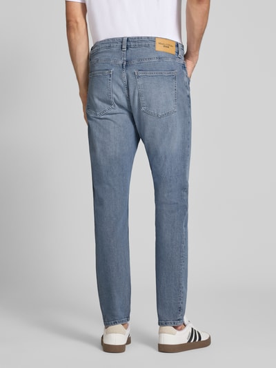 Männermodel trägt Tapered Fit Jeans aus Baumwoll-Mix von Marc O'Polo Denim in hellem Blau, sichtbare Taschen, Ganzkörperansicht Rückansicht. Herren Tapered Fit Jeans von Marc O'Polo Denim.
