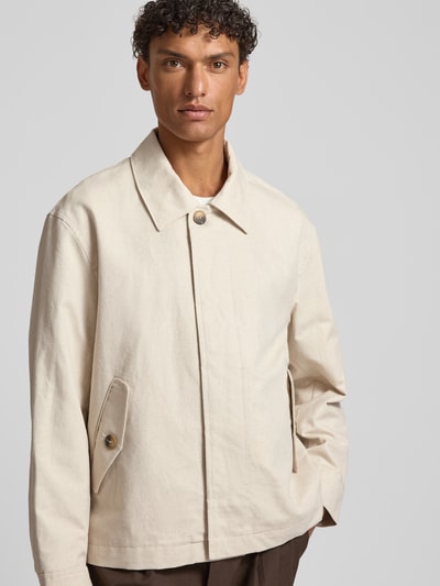 Męski model nosi Regular Fit Hemdjacke aus Leinen-Baumwoll-Mix Modell 'LEWIS' od SELECTED HOMME, jasny beż, gładka faktura, krój regular fit, z kołnierzem koszulowym, zapięcie na guziki, naszywka z logo, długie rękawy, kieszenie z patką, materiał flammgarn, widok całego przodu.