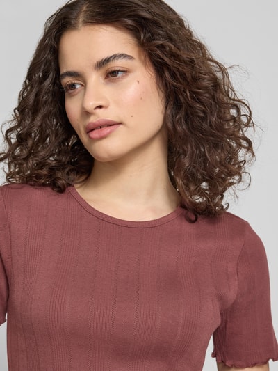 Frauenmodel trägt Damen T-Shirt von Only Modell 'TENNA' in Optik: Unifarben, Slim-Fit, Rundhals, Kurzarm, Frill-Abschluss, Baumwoll-Mix, Nahaufnahme Oberkörper.